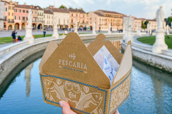 Pescaria Padova: confezione take away con logo Pescaria e decorazioni a tema pesce.