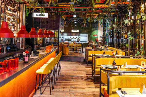 Interni del ristorante Doppio Malto: bar arancione, sedute gialle, decorazioni verdi. Nuovo locale a Verona.