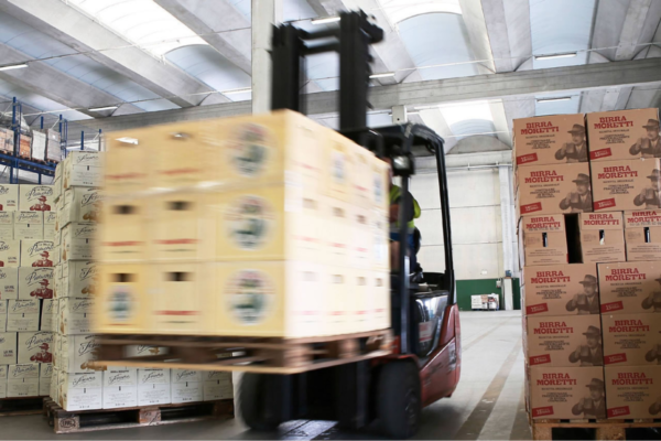 Magazzino Partesa: carrello elevatore con casse di birra Moretti e Peroni. Servizio tailor made e digitale.