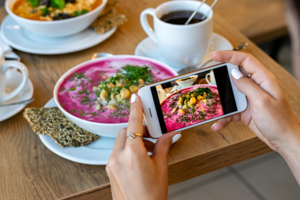 Marketing food: foto a zuppa di barbabietole con smartphone. Tecniche di marketing 2022.