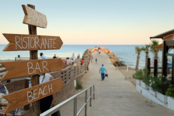 Cartelli indicatori per ristorante, bar e spiaggia. Beach club con passerella sul mare.