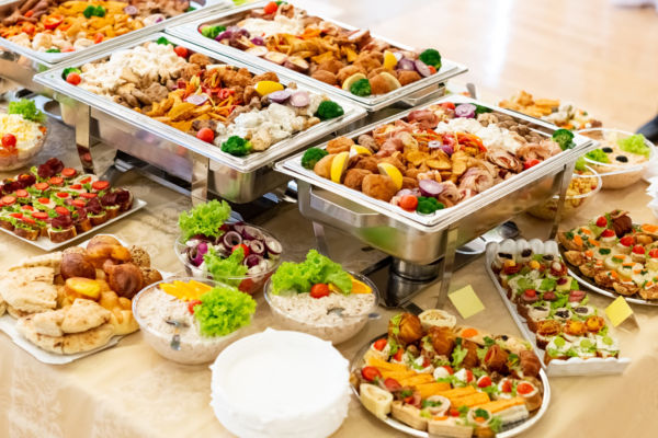 Buffet aziendale con vassoi di cibo caldo e stuzzichini. Pranzo al ristorante aziendale per i lavoratori.