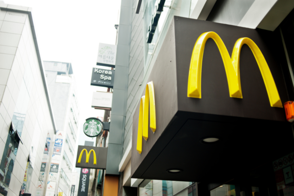 Insegne McDonald's e Starbucks in strada. Ristoranti e marchi globali in città. Vendita McDonald's Russia.
