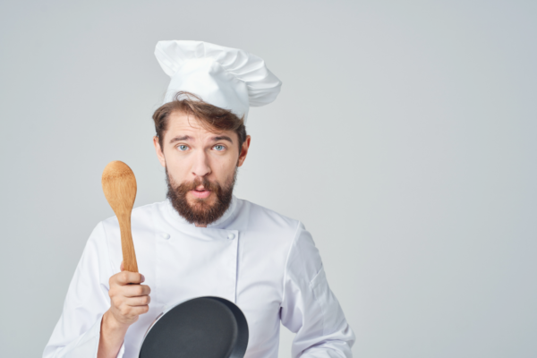 Chef italiano con mestolo e padella. Ristorazione in crescita.