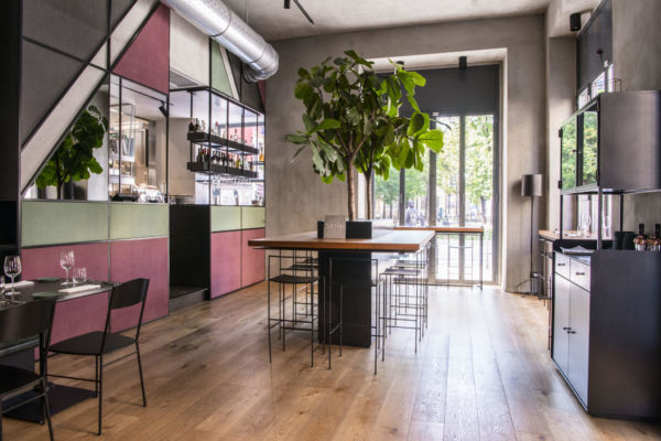 Interni di Rua, Milano. Design moderno, tavolo conviviale, pianta decorativa. Nuovo ristorante a Milano.