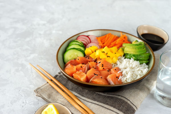 Ami Poké Roma: colorata bowl con salmone, riso, mango, avocado, cetrioli e carote. Cucina hawaiana.