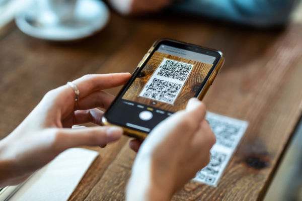 Smartphone che scansiona QR code al ristorante. Ordina e paga facile!
