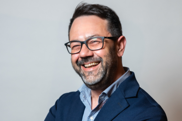 Uomo sorridente con occhiali. Ferro Distribuzione, partner Horeca.