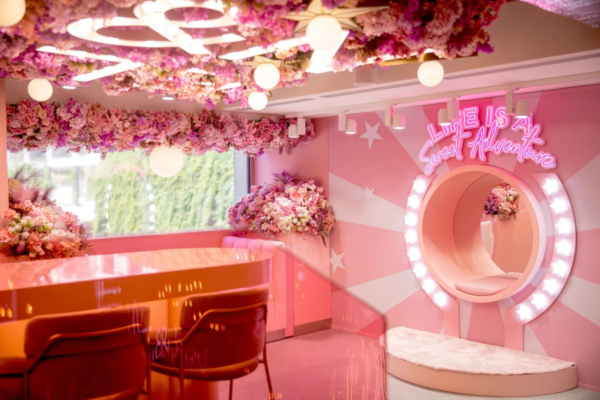 Interni rosa del locale EL&N in Italia. Design floreale, insegna al neon Life is a Sweet Adventure. Food & beverage.