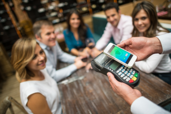 Pagamento digitale: POS con smartphone per mance e pagamenti cashless al ristorante.