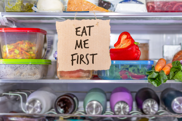 Frigo pieno di cibo con cartello Mangiami subito. Stop allo spreco alimentare in Spagna.