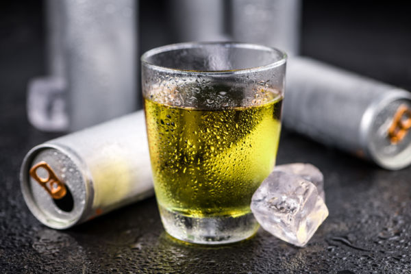 Energy drink San Benedetto in vetro con lattine e ghiaccio. Bevanda energetica fresca.