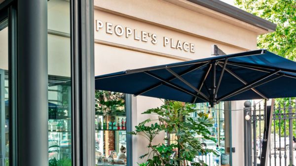 People's Place: esterno del locale. Insegna, ombrellone blu e vetrate. Un luogo accogliente dove sentirsi a casa.