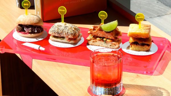 People’s Place: Assortimento di mini panini gourmet e cocktail rossi su vassoio. Tommy Yummy, cibo creativo.