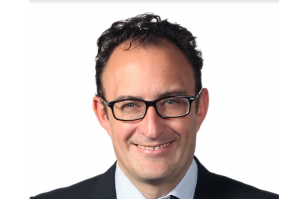 Ritratto del nuovo DG di Carlsberg Italia, sorridente e con occhiali.