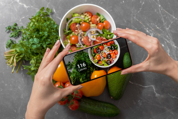 Monitoraggio calorie: foto smartphone di insalata e verdure fresche. Tendenze food industry italiana.