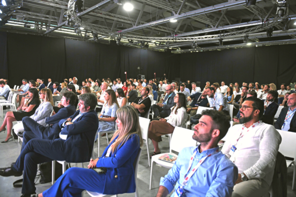 Conferenza NGR: pubblico attento al futuro del fuori casa. Evento, persone sedute.