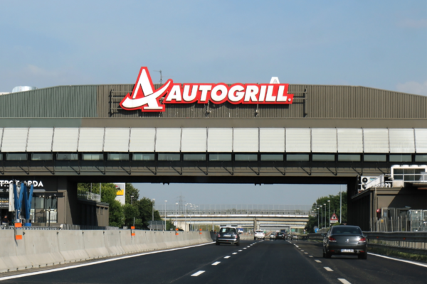 Autogrill in autostrada. Ristorazione e servizi per viaggiatori in Italia. Logo Autogrill ben visibile.