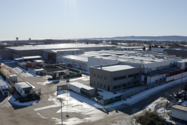 Stabilimento Coca-Cola di Biella riapre. Vista aerea dell'impianto produttivo in modalità green con neve.