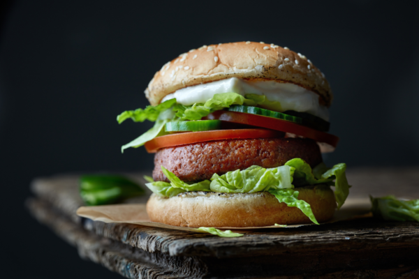 Heura burger vegano. Panino con burger vegetale, pomodoro, cetriolo, lattuga e salsa.