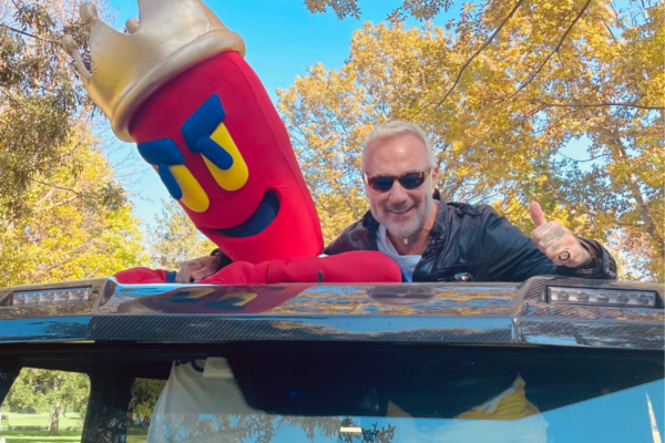 Apertura Kebhouze Taranto: uomo e mascotte kebab su auto. Evento street food, divertimento e promozione.