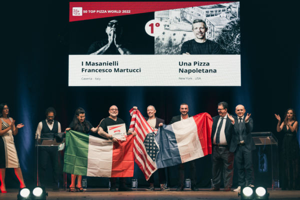 Premiazione 50 Top Pizza World 2022: Anthony Mangieri e pizzaioli con bandiere.