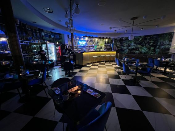 Cena a lume di candela in locale elegante. Tavoli illuminati, atmosfera intima, caro-bolletta.
