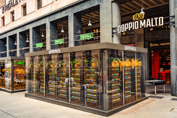 Doppio Malto Duomo Milano. Facciata del locale con birre artigianali in esposizione e insegna luminosa.