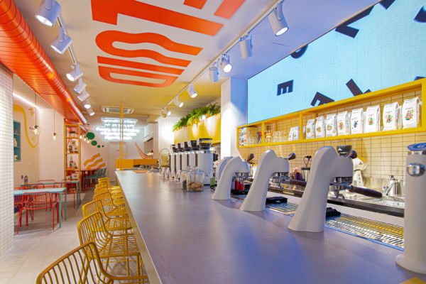 Interni colorati di Fluid, nuova caffetteria. Design moderno, bancone bar, sedie gialle.