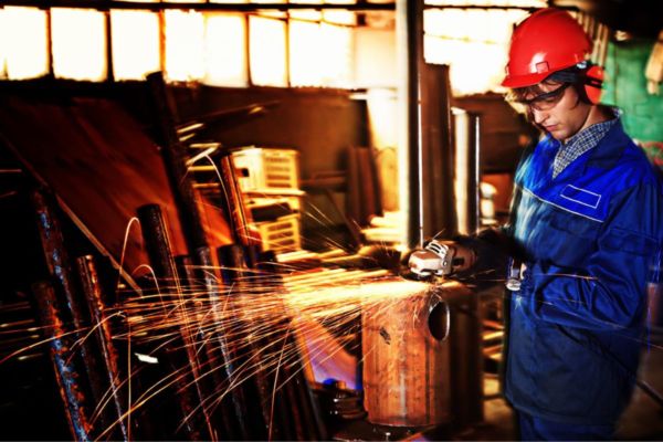 Operaio al lavoro con macchinario. Crisi aziende macchinari Horeca. Attrezzature industriali, sicurezza.