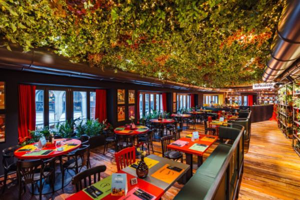 Interno Doppio Malto Milano Duomo. Tavoli colorati, verde pensile, atmosfera accogliente. Ristorante, birreria.
