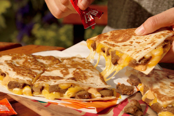 Quesadilla plant based Taco Bell con formaggio fuso e salsa piccante.
