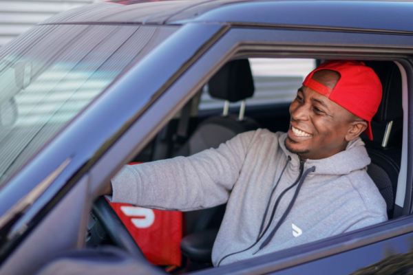 Consegna USA: uomo sorridente in auto con borsa per la consegna di cibo. Piattaforme per ristorazione.