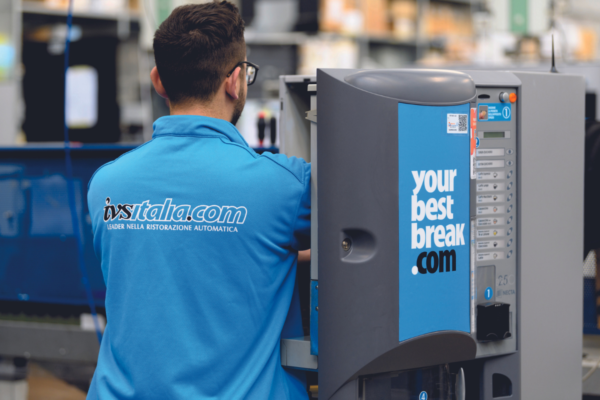 Macchina caffè IVS Group. Uomo con polo IVS Italia. Soluzioni per la ristorazione automatica e pausa caffè in azienda.