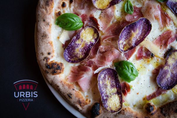 Pizza gourmet contemporanea con patate viola, prosciutto e basilico. Pizzeria d'Italia.