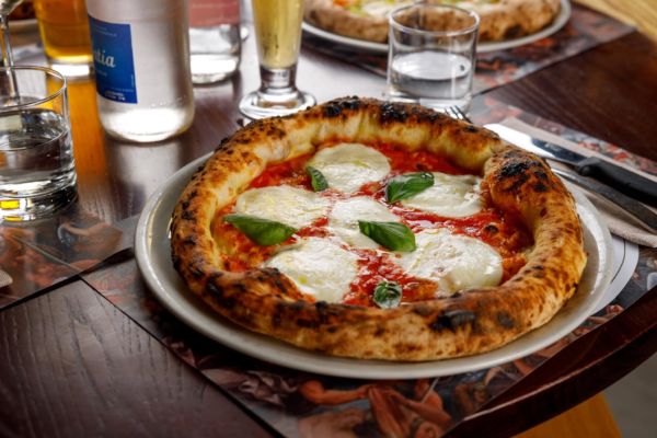 Pizza napoletana contemporanea con mozzarella e basilico. Pizzeria d'Italia.