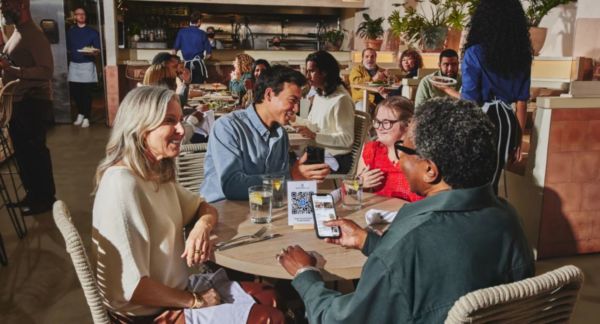Clienti al ristorante usano QR code per il menù digitale. Ristorazione moderna, tecnologia, innovazione.