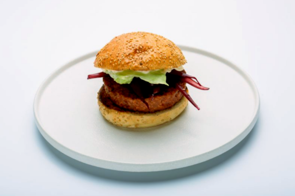 Hamburger healthy Mediterranea Milano. Panino con burger, insalata e radicchio su piatto bianco.