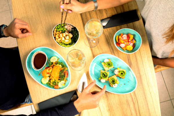 Pacifik Poke: tavolo con poke bowl, insalate e toast avocado. Cucina fusion e sana.