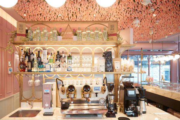 Arredamento bar stile neoclassico AFA: scaffali dorati con liquori, macchina caffè professionale, decorazioni floreali.