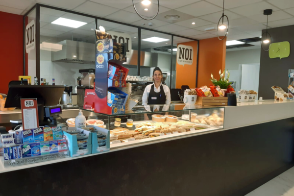 Nuova apertura Camst Group al WTC Genova: bancone bar con vetrina di prodotti freschi e personale sorridente.