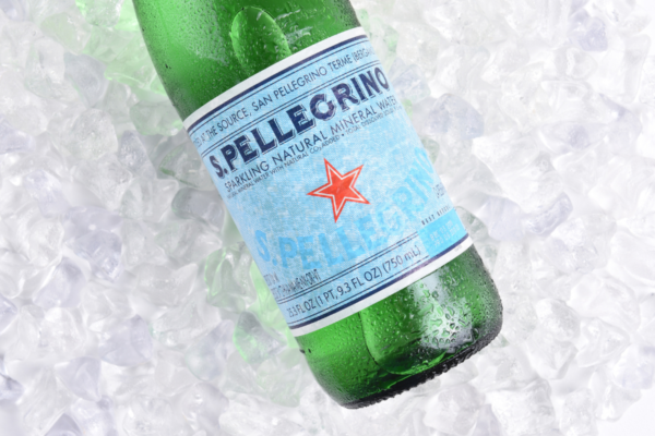 Bottiglia San Pellegrino su ghiaccio. Acqua minerale frizzante, crescita vendite.