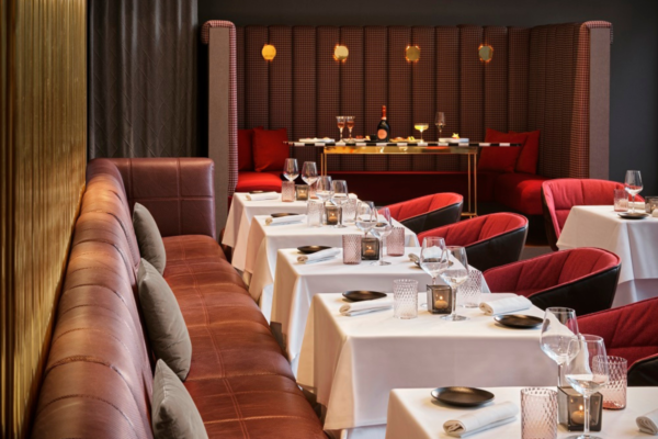 Interni eleganti del ristorante Rivington a Milano. Tavoli apparecchiati e divanetti in pelle. Cucina raffinata.