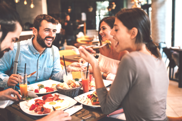 Amici a pranzo al ristorante. Foodservice e delivery: new normal con piatti e bevande.