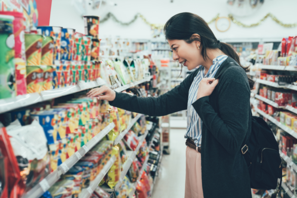 Donna in C-store USA. Trend ristorazione 2023: acquisti snack e prodotti confezionati.
