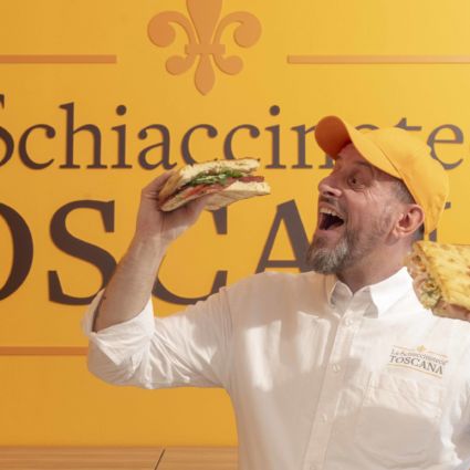 Uomo felice con schiacciata toscana. Franchising La Schiaccinoteca Toscana.