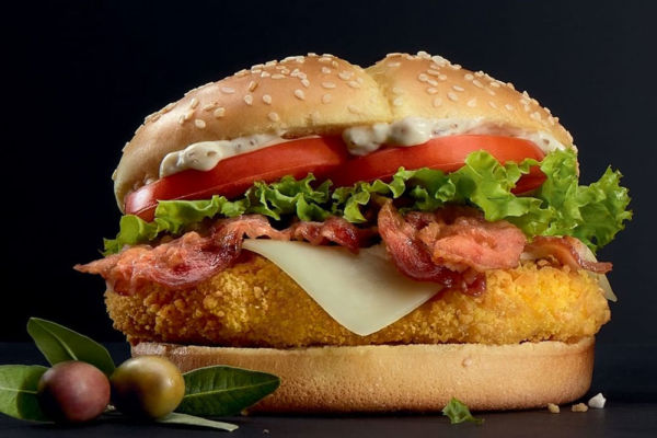 Panino McDonald's. Hamburger con pollo, bacon, formaggio, lattuga e pomodoro.