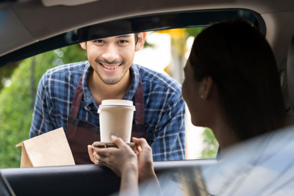 Ristorante Quick Service: barista consegna caffè e cibo da asporto.