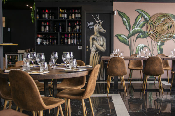 Interno ristorante La Filetteria Italiana: tavoli apparecchiati, sedie marroni, scaffale vini, murales artistici.