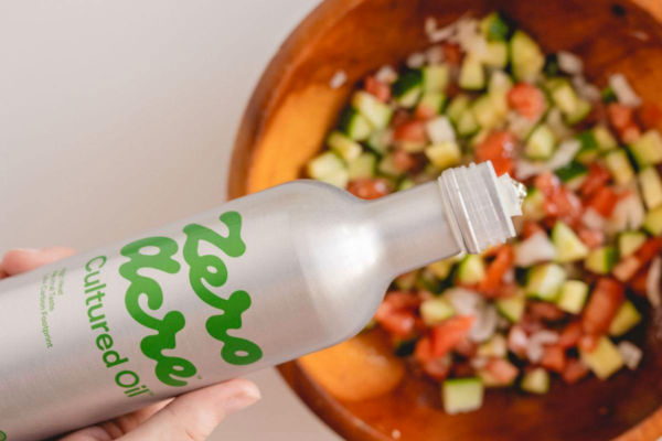 Olio Zero Acre per Chipotle. Bottiglia olio su insalata. Investimenti Chipotle in ingredienti innovativi.